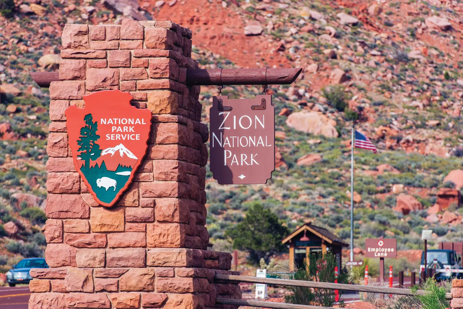 Panneau d'entrée de Zion National Park avec guérite et drapeau américain